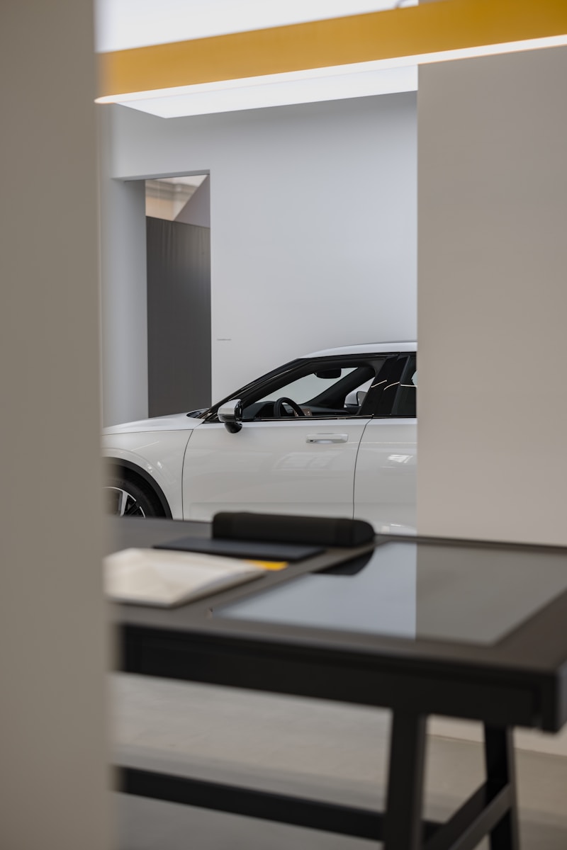 a white car is parked in a showroom, auto insurance